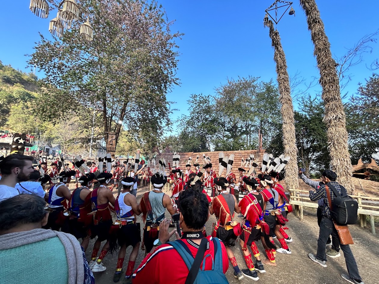 Cultural performers gathered beneath decorated poles at Hornbill Festival