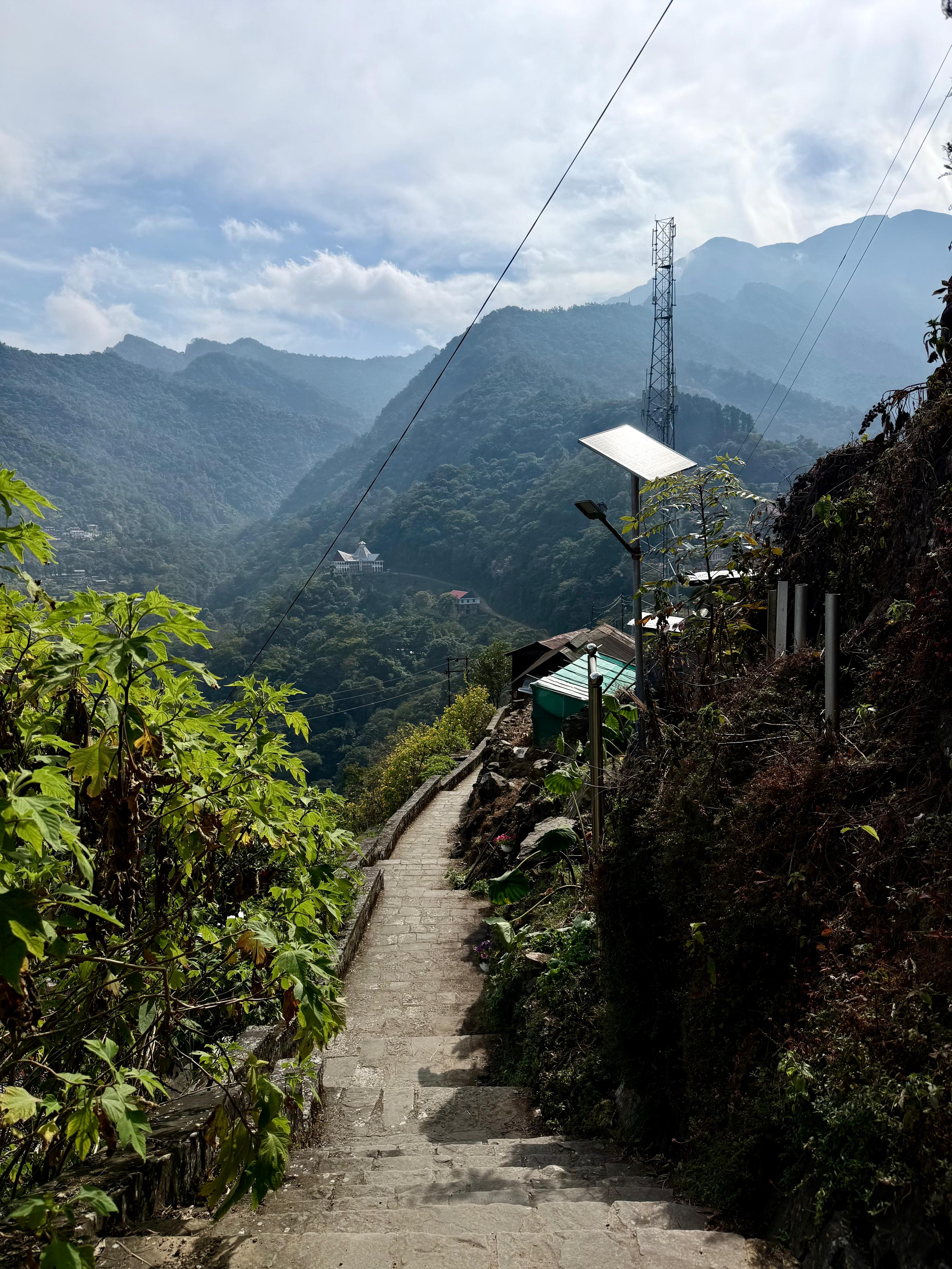 A stepped village path overlooking green hills